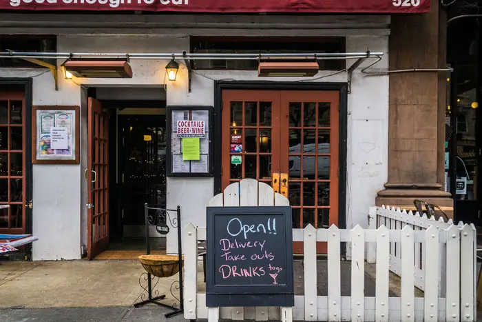 A restaurant on the Upper West Side has a sign reminding people they have food and drinks to go